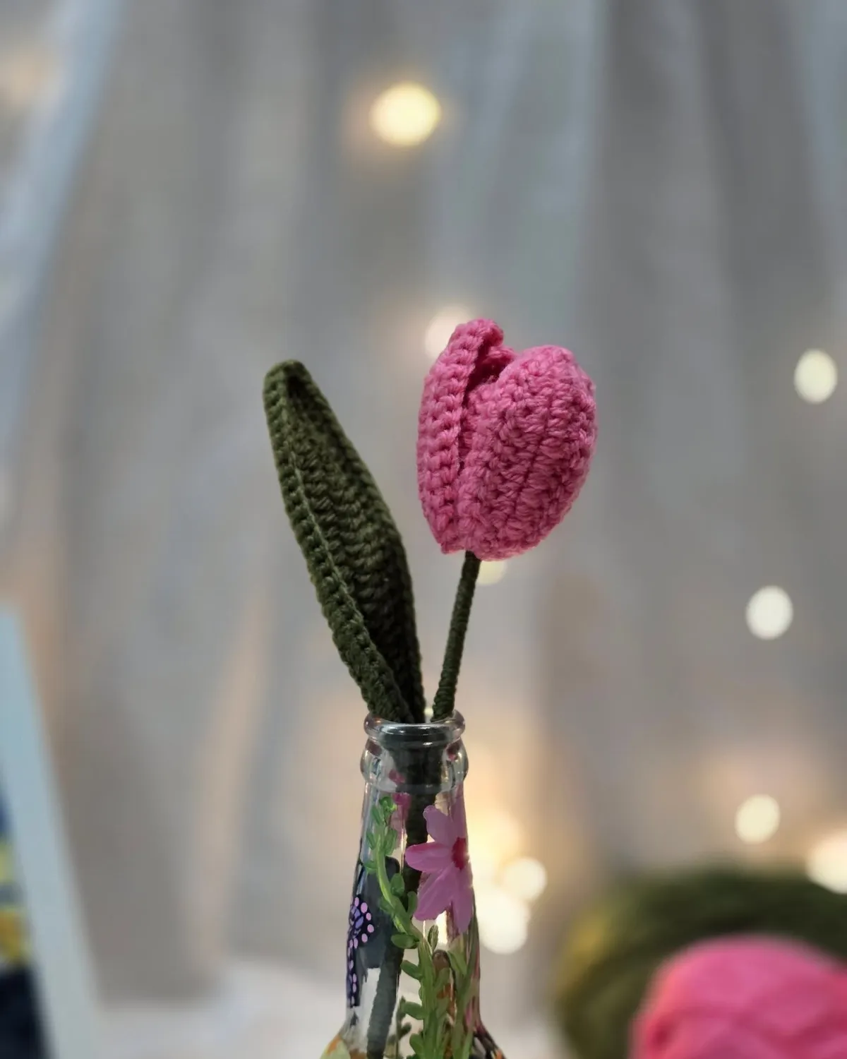 Hand-crocheted tulip in a painted glass bottle